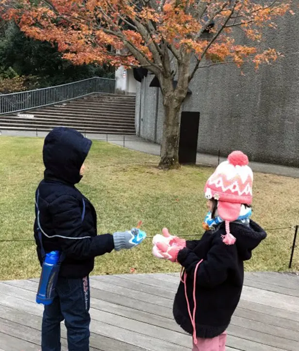 Brother and sister on the lawn at the Hakone Open-Air Museum, wrapped up for winter
