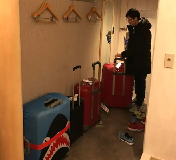 Our four big suitcases in a small hotel room